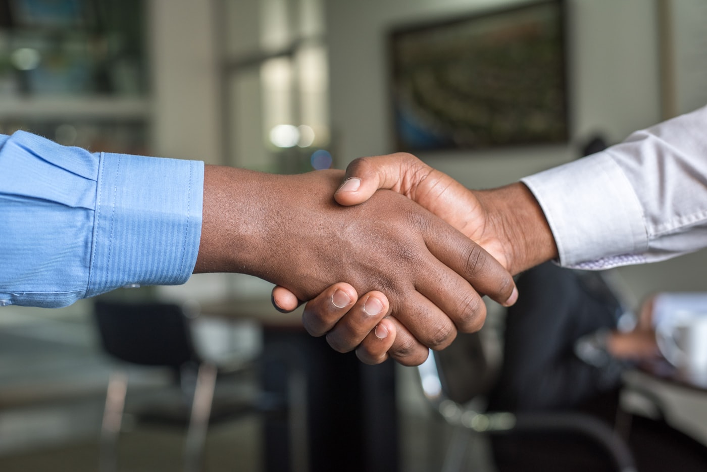 Two people shaking hands over a business agreement